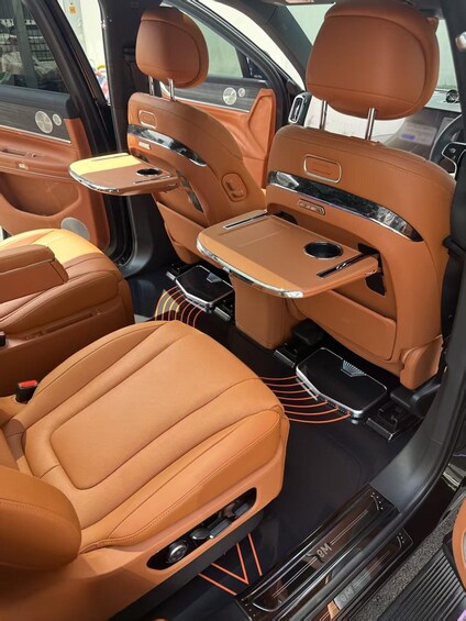 A luxury car interior with brown leather seats, a center console, and a sunroof. 2