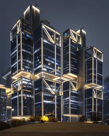 A modern high-rise building with illuminated structural elements at night. 4