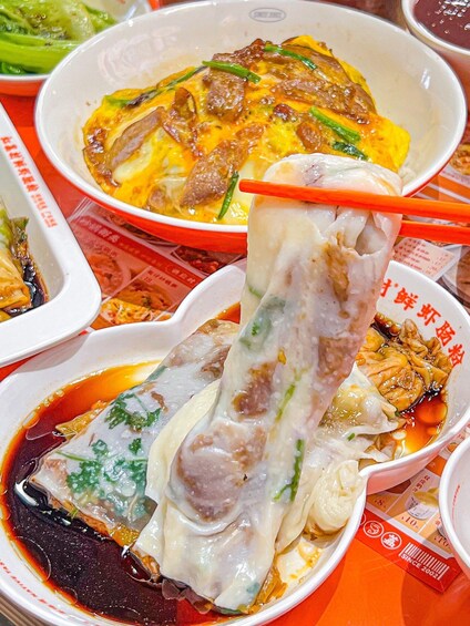 A variety of Asian dishes, including a dish with a translucent dumpling and a bowl of soup with meat and vegetables. 4