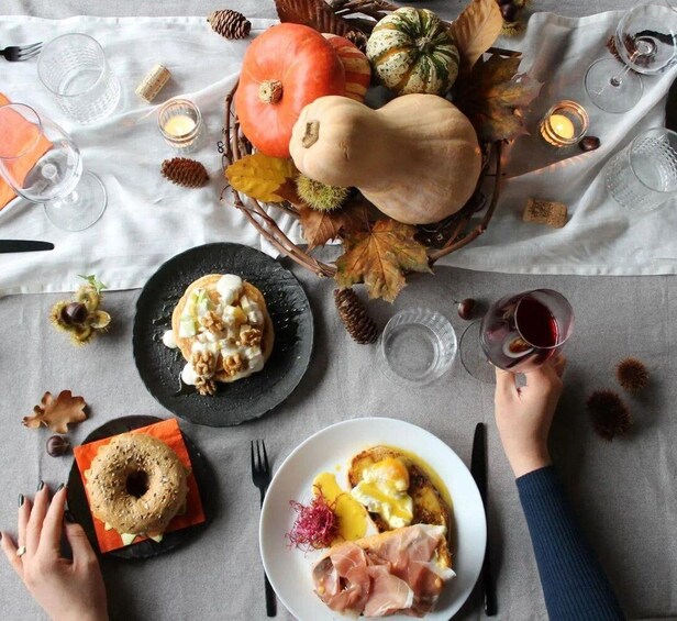 A table with autumn-themed decorations, including pumpkins, gourds, and candles. 1