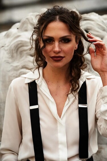 A person wearing a white shirt with black suspenders. 3