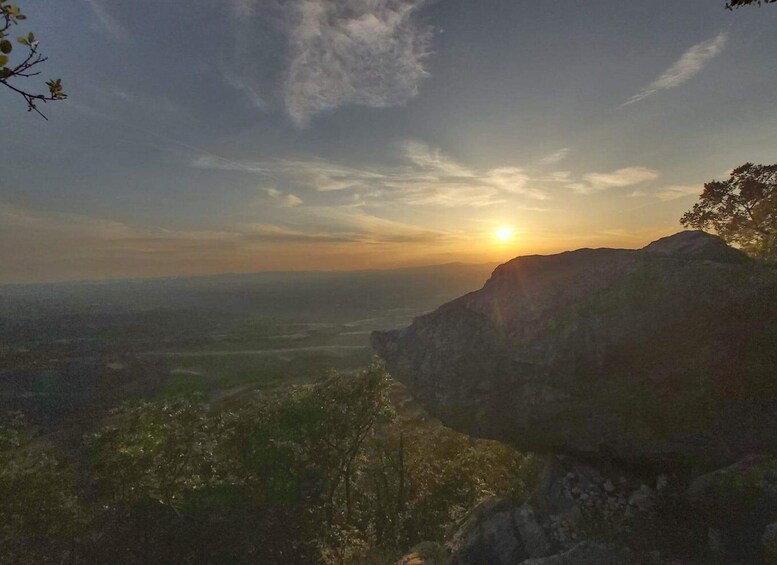 A sunset over a mountainous landscape with a valley below. 4