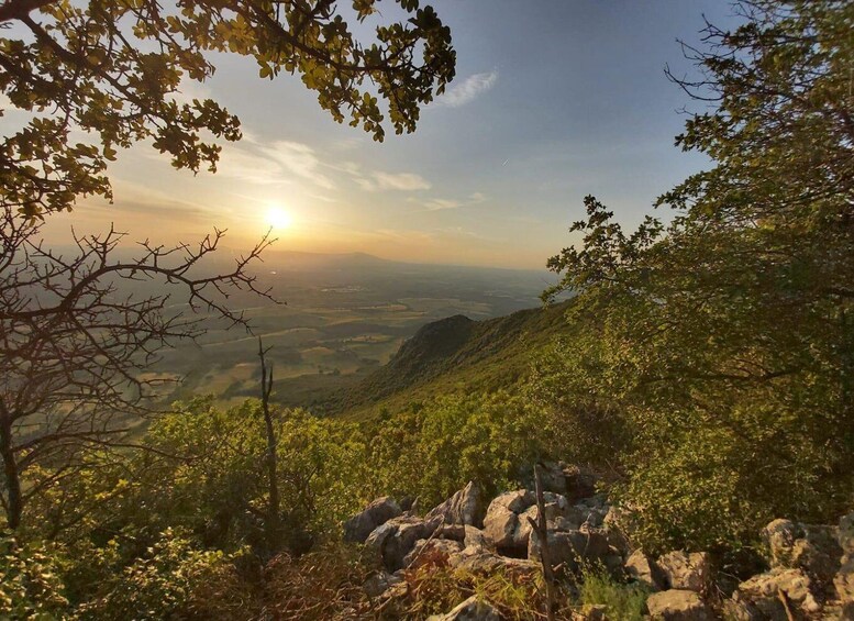 A mountainous landscape with a view of the valley below, a clear sky, and the sun setting or rising. 5
