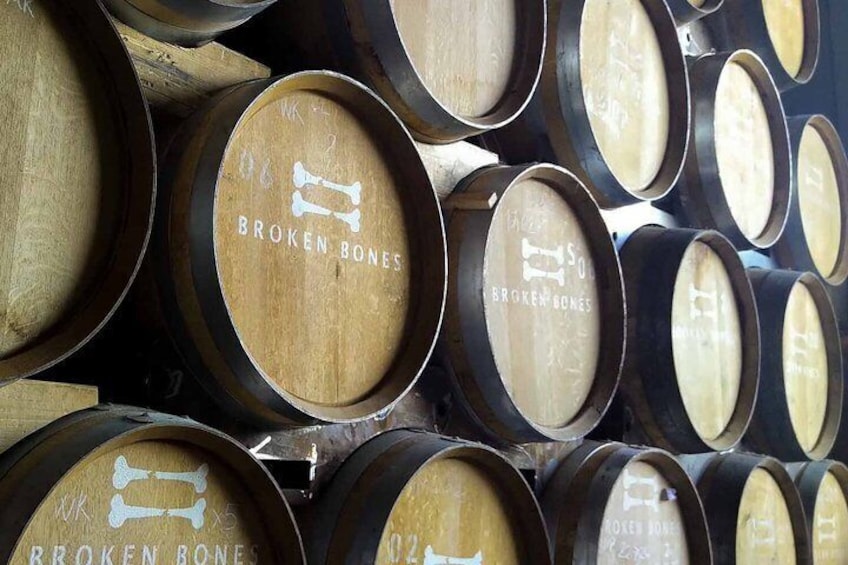 Wooden barrels stacked closely together with 'BROKEN BONES' text on them. 3