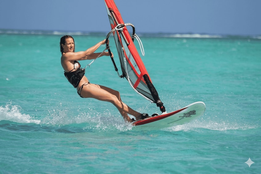 A person windsurfing on turquoise water. 4