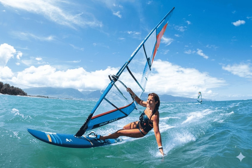 A person windsurfing on a clear day with a blue sky and calm sea. 1