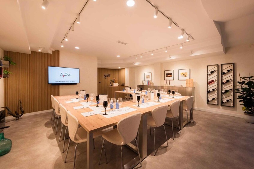 A conference room with a long table set for a meeting, a TV screen, and framed pictures on the wall. 3