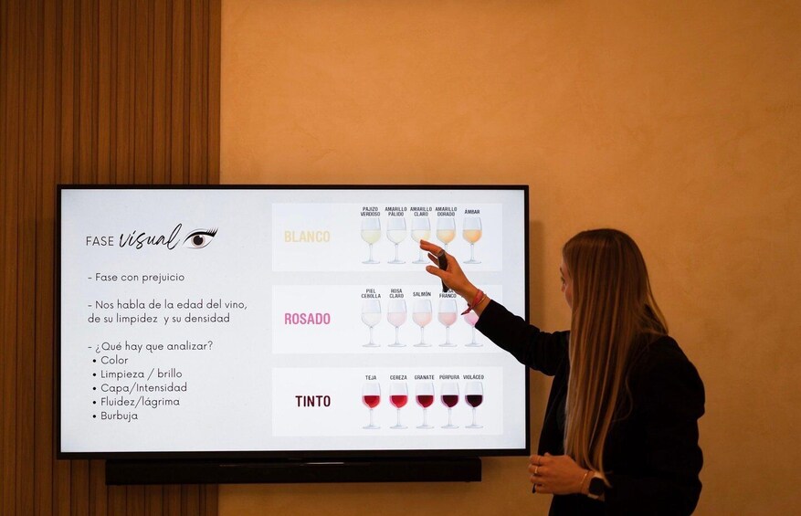 A presentation on wine tasting phases with a person pointing at the screen. 4