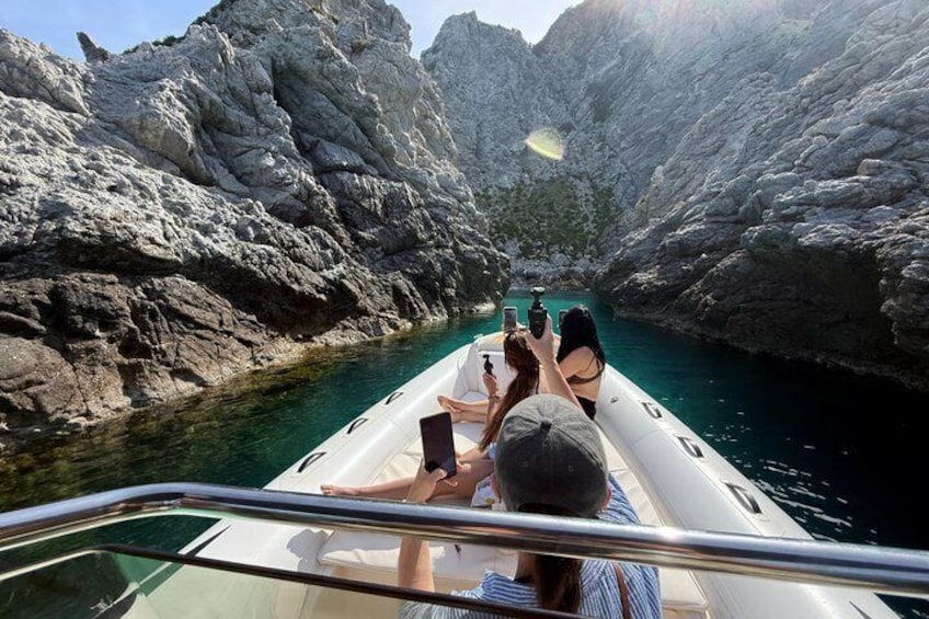 A boat navigating a narrow waterway between rocky cliffs. 1
