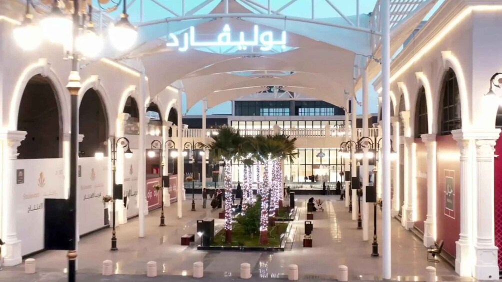 A spacious indoor shopping area with arches, columns, and decorative lighting. 2