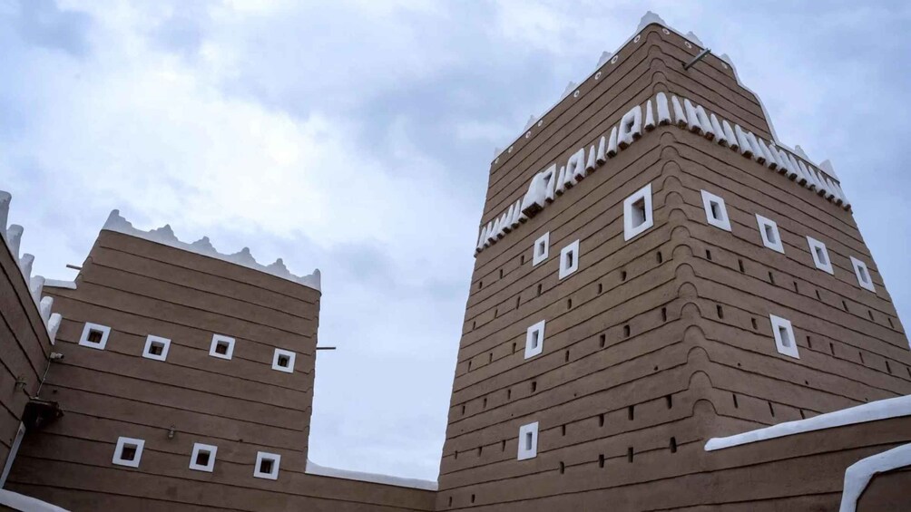 A building with a unique architectural design featuring multiple windows and a textured facade. 1