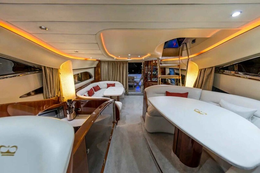 A luxurious interior with a white sofa, a dining table, and a bar area. 3