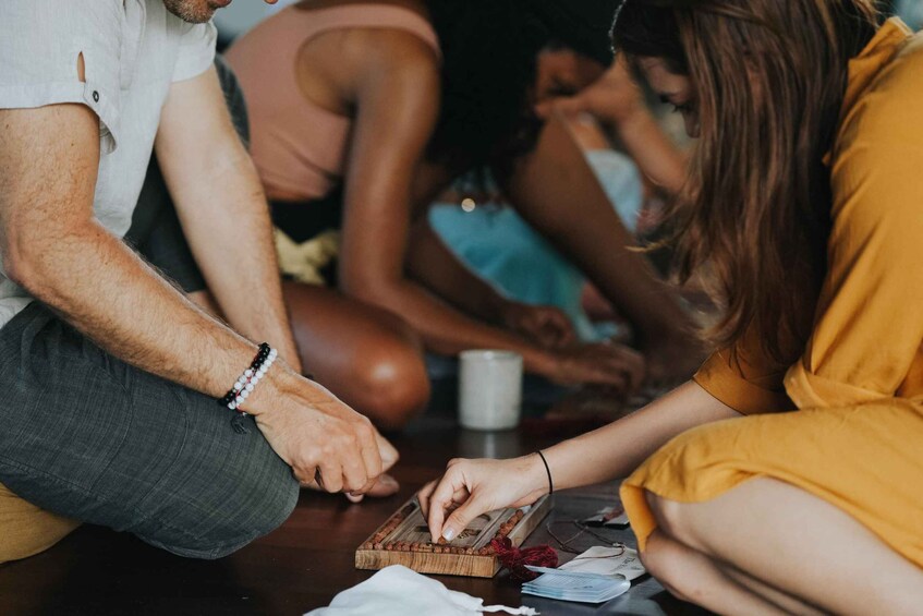 People sitting on the floor, playing a board game. 4