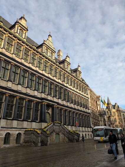 A historic building with ornate architecture, a cobblestone street, and a bus in the background. 5