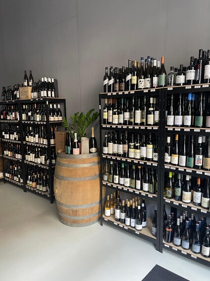A wine store with shelves of wine bottles and a wooden barrel. 5