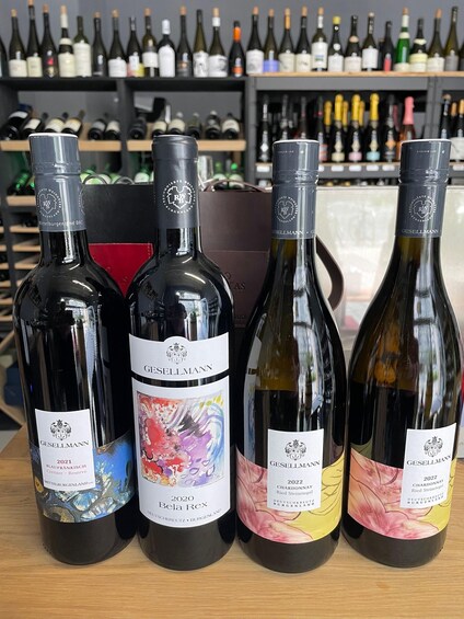 Four bottles of wine with labels, placed on a table in a wine shop. 3