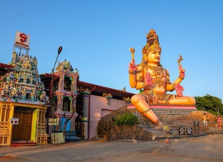 A large statue of a deity with multiple arms, a temple with intricate architecture, and a clear blue sky. 4