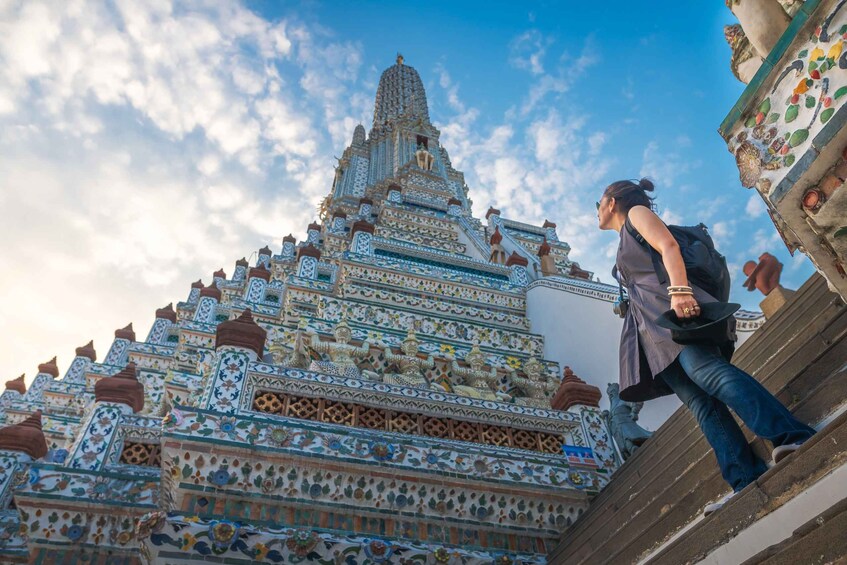 A person ascending steps towards a temple with intricate blue and white patterns. 1