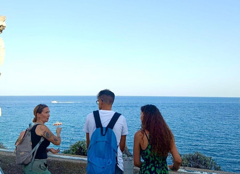 Three people standing by the sea, overlooking the ocean. 3