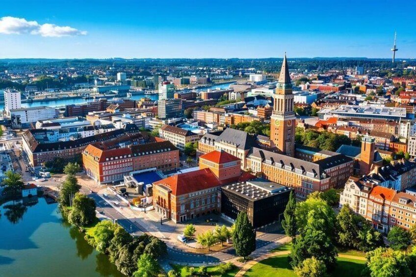 A cityscape with a prominent tower, a river, and a mix of historic and modern buildings. 1