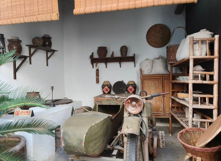 A rustic interior with traditional pottery, a wooden shelf, and a motorized device covered in a tarp. 4