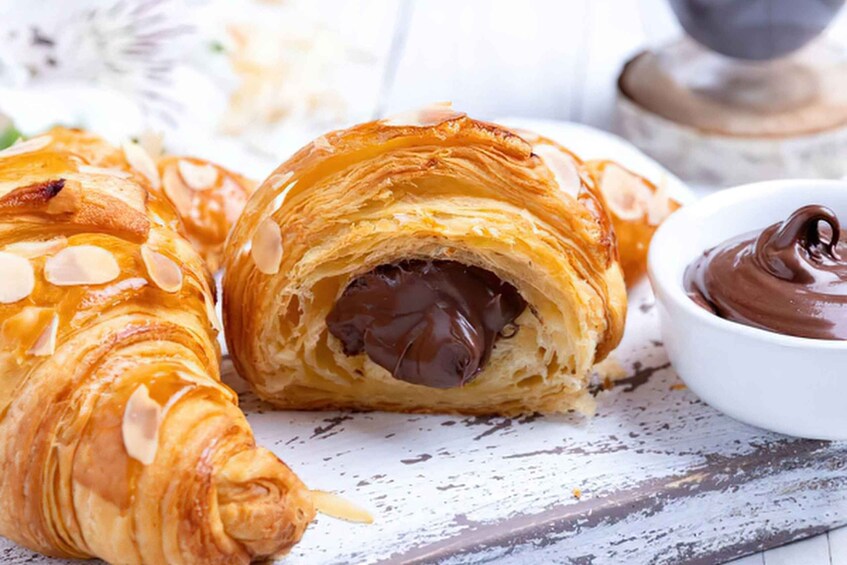 A pastry with chocolate filling and almonds, accompanied by a chocolate spread. 4