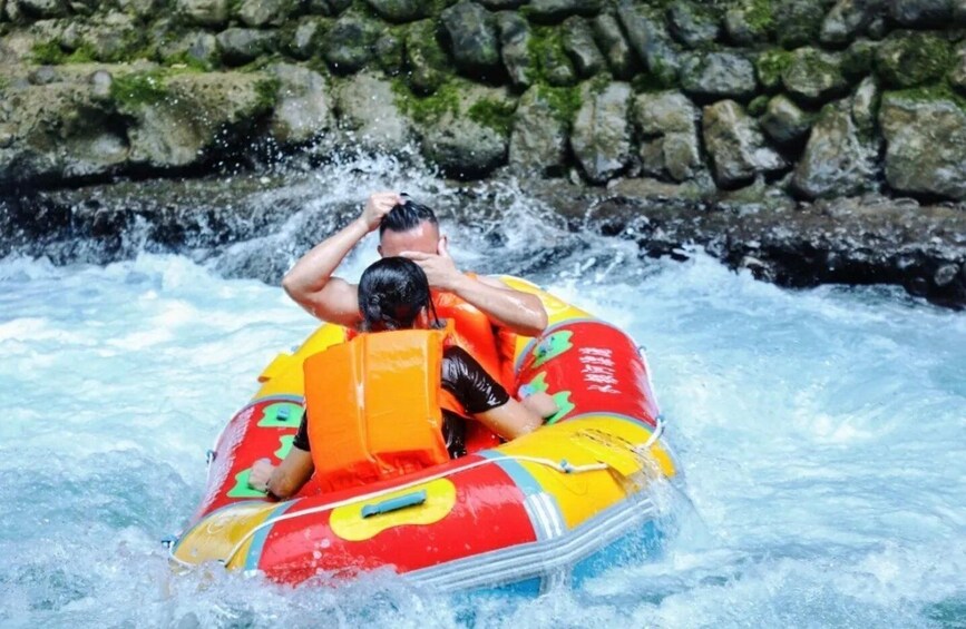 Two people in a colorful inflatable raft navigating through rapids. 1