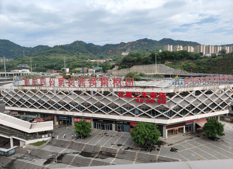 A modern building with a grid-like facade, surrounded by a parking lot and a mountainous landscape in the background. 2