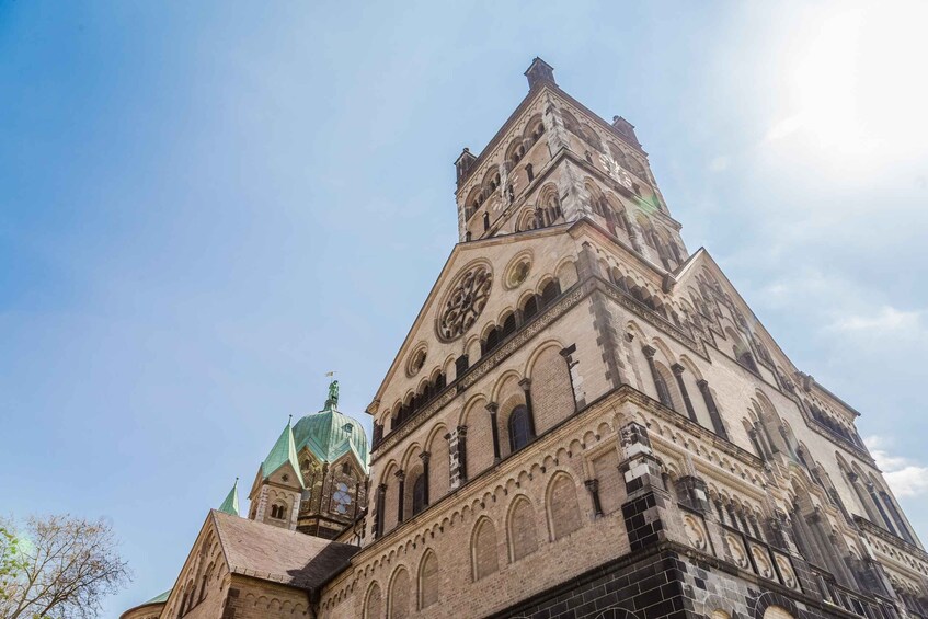 A historic church with a prominent clock tower and green domes. 4