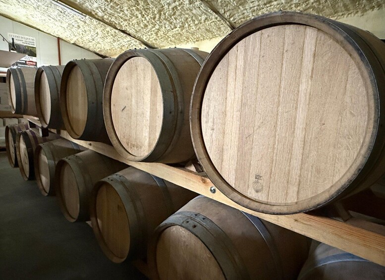 Wooden barrels stacked on wooden shelves in a warehouse. 5