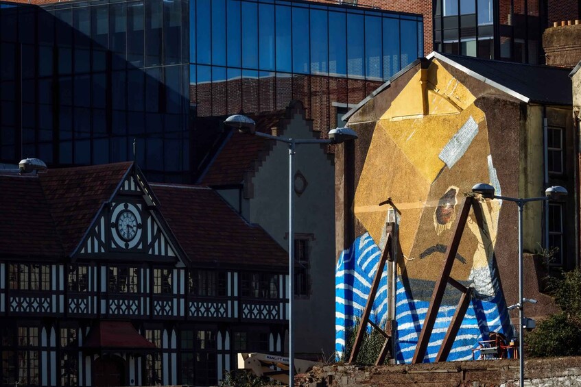 A traditional half-timbered building, a modern glass building, and a construction site with a large mural. 4