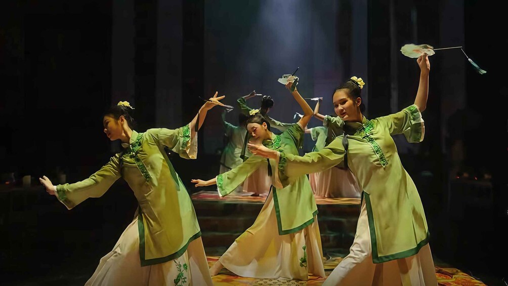 A group of dancers in traditional costumes performing on a stage. 5
