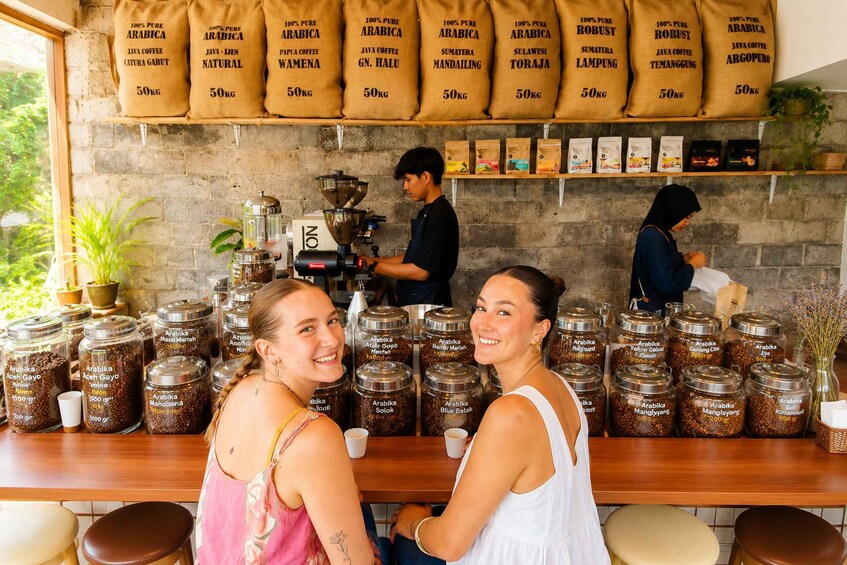 A coffee shop with a barista preparing coffee, and two customers seated at the counter. 5