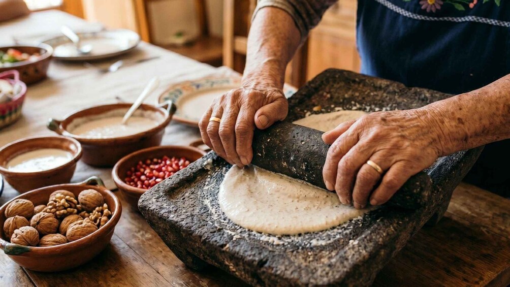 An individual using a traditional stone mill to grind grains. 2
