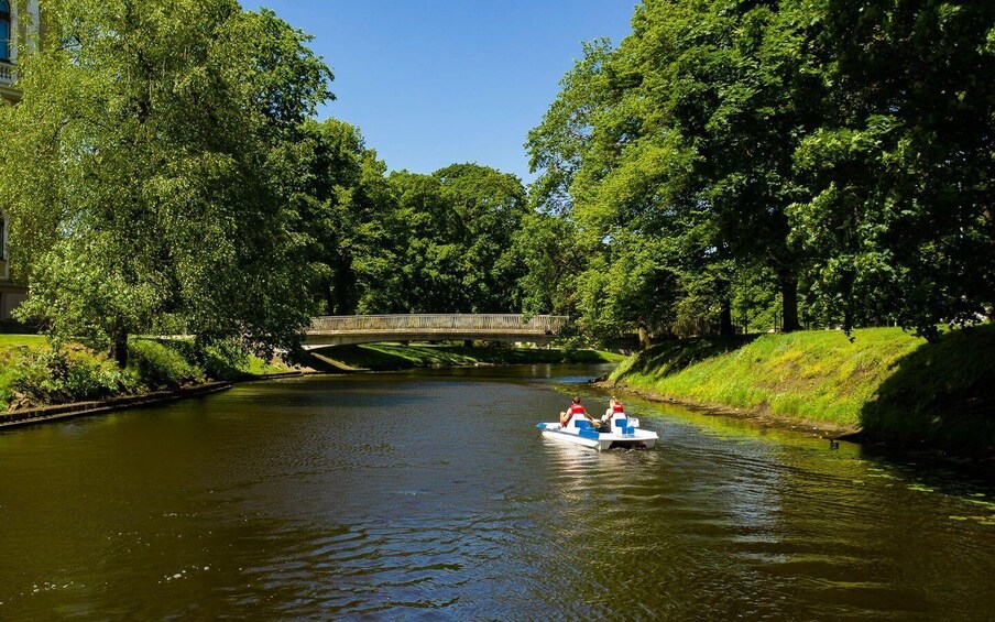 A river with a bridge and a boat with two people. 5