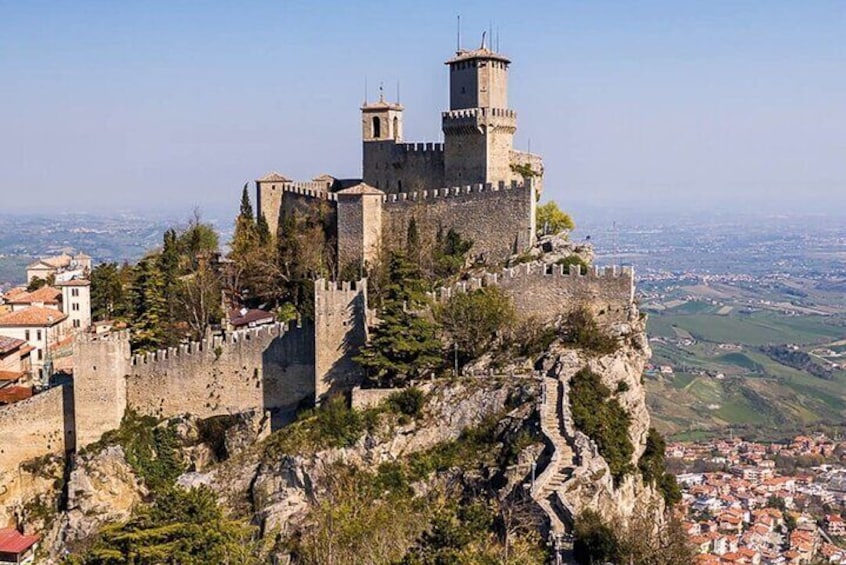 A historic castle perched on a cliff overlooking a city. 1