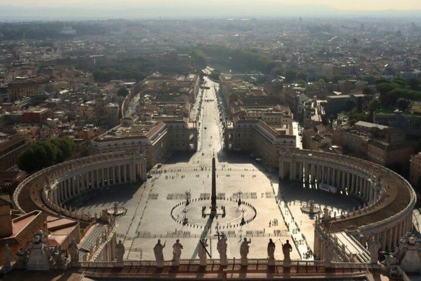 A grand open space with a central circular area, surrounded by classical architecture and a large colonnade. 5