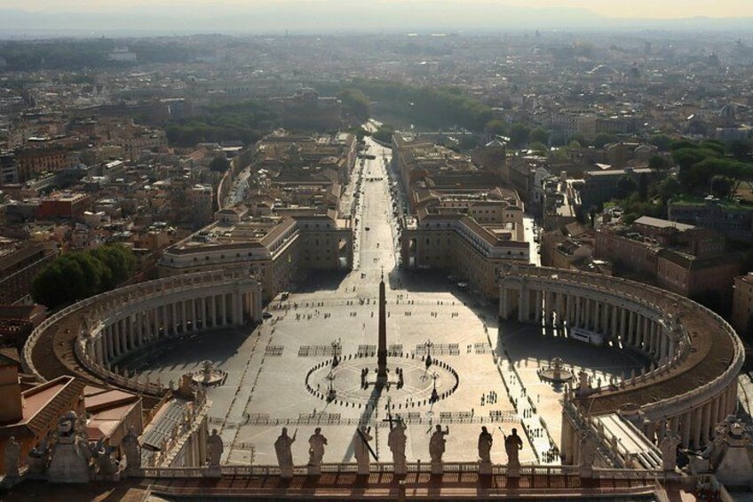 A grand open plaza with a central circular area, surrounded by classical architecture and a distant cityscape. 4