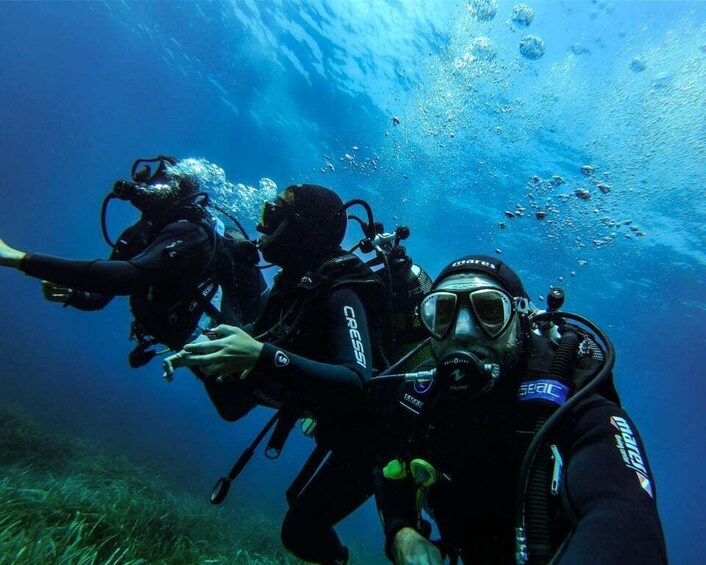 Two scuba divers underwater with bubbles rising to the surface. 3