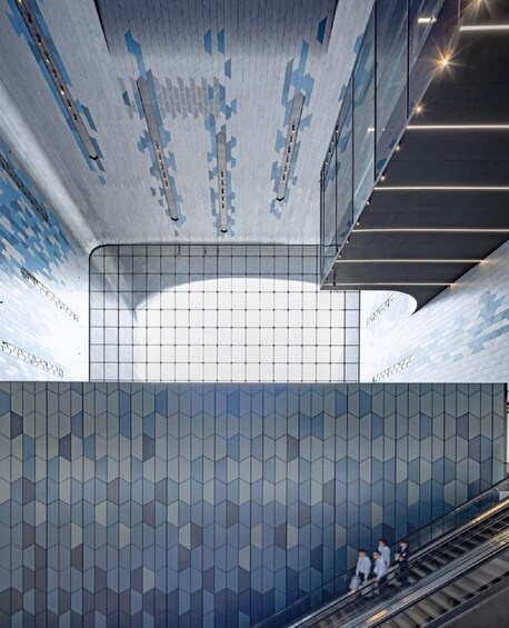 A modern architectural interior with geometric ceiling patterns, a grid-like floor, and a reflective wall. 4