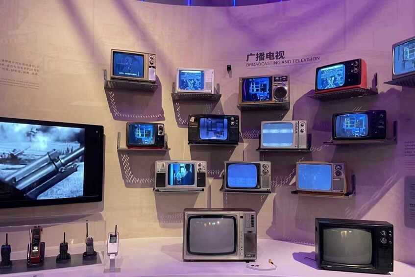 A display of various television sets and mobile phones on a wall. 1