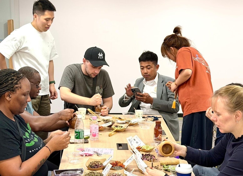 A group of people sitting around a table with various food items and drinks. 2