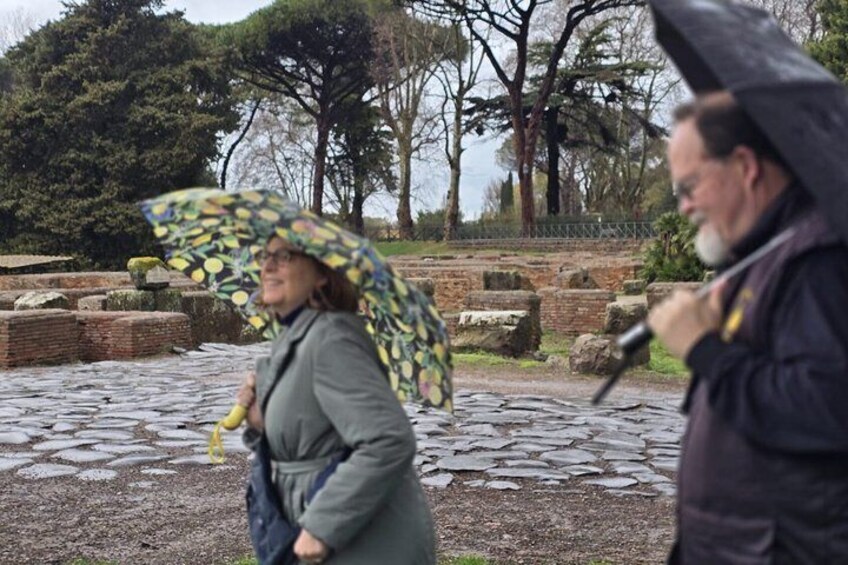 A person holding a patterned umbrella walking on a stone path. 4