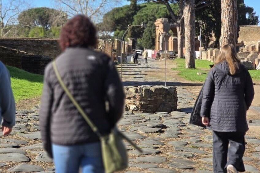 A historical site with stone ruins and visitors walking. 2