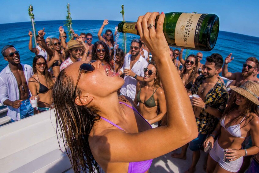 A person pouring champagne at a beach party. 2