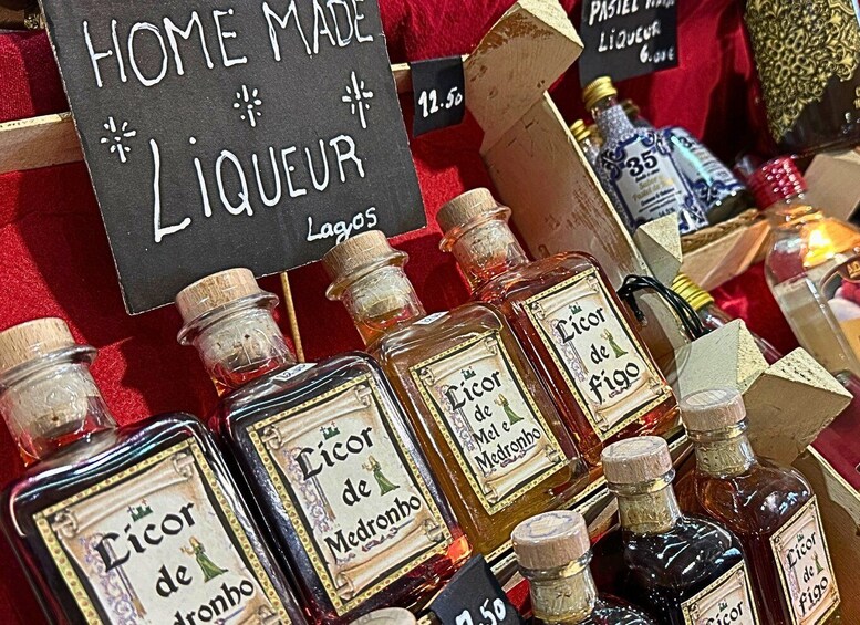A display of homemade liqueurs with labels and price tags. 5