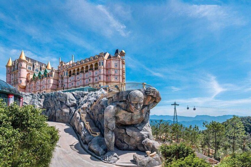 A castle-like building, a large statue of a man, and a mountainous landscape. 3