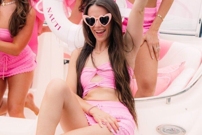 A person in a pink outfit sitting on a boat. 5