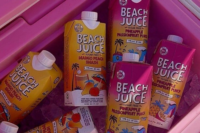A pink cooler containing various flavors of Beach Juice, including Mango Peach Smash and Pineapple Passionfruit Punch. 3