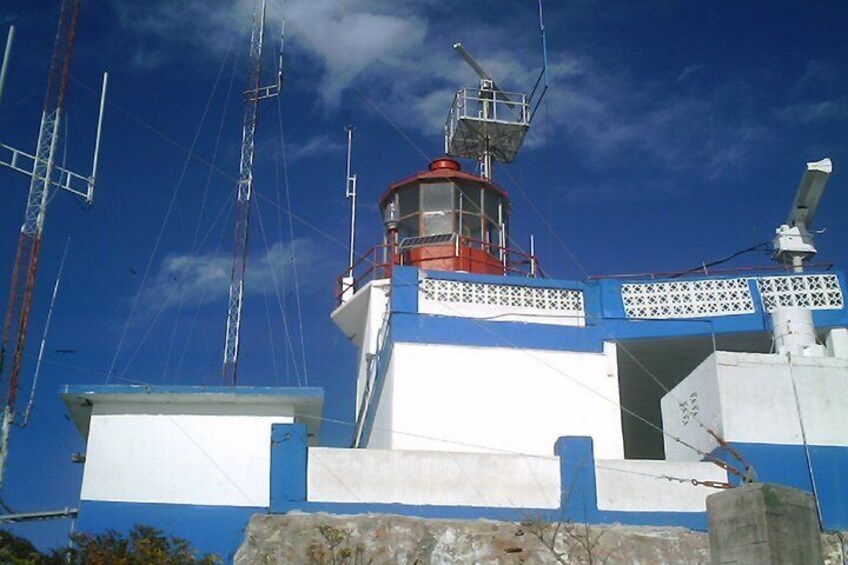 A lighthouse with a red top, blue and white walls, and a white door. 1